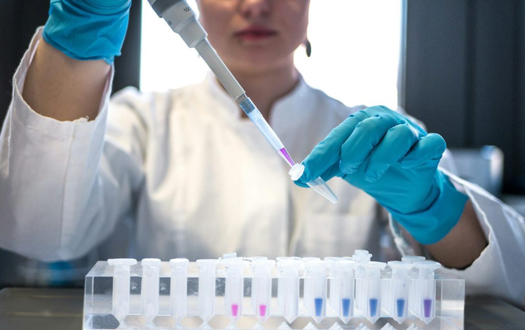 A laboratory technician pipetting samples into tubes