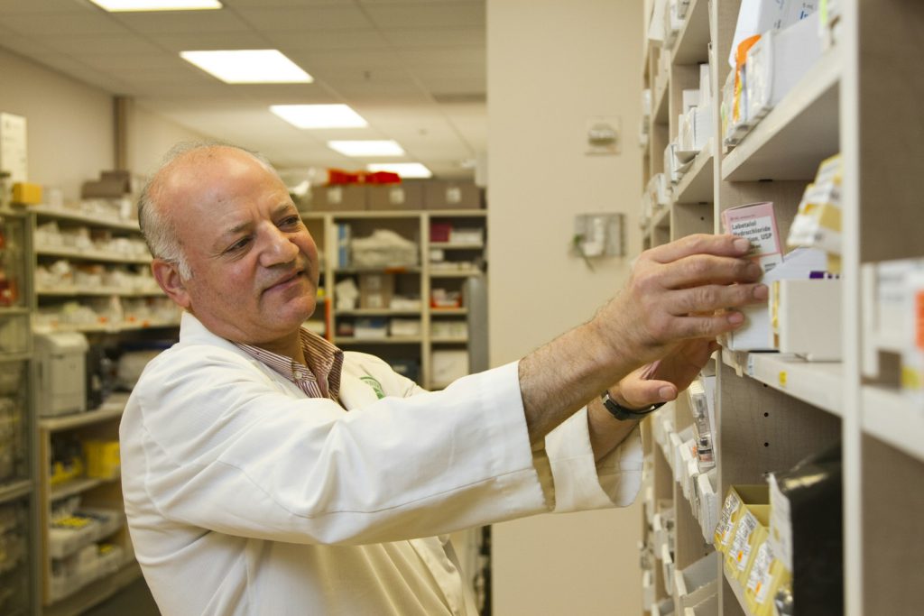 A pharmacist selecting medicines from a shelf
